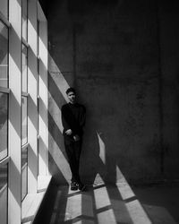 Man standing by wall of building