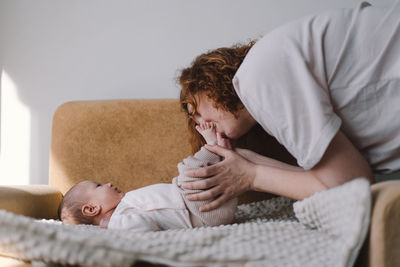 Portrait of happy mum holding infant child on hands.