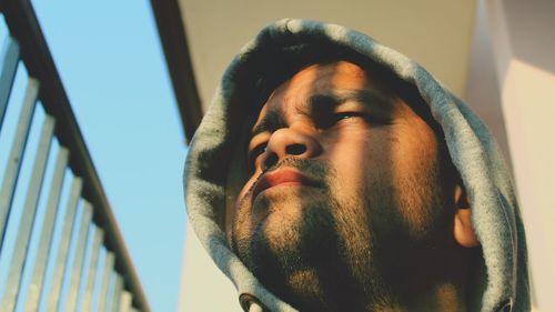 Low angle view of mid adult man looking away by railing