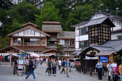 People on street amidst buildings in city