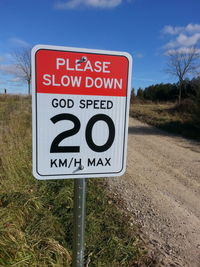 Close-up of road sign against sky