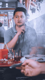 Portrait of young man sitting at restaurant