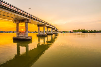 Bridge over river against sky during sunset