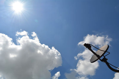 Low angle view of silhouette crane against sky on sunny day