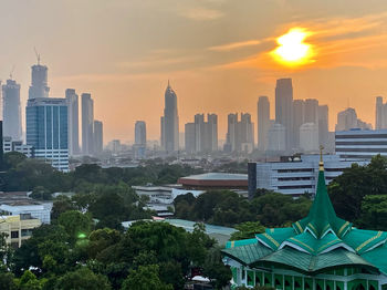 View of buildings against cloudy sky during sunset
