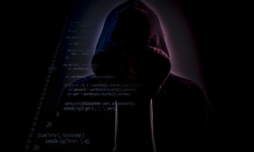 Close-up of man using mobile phone against black background