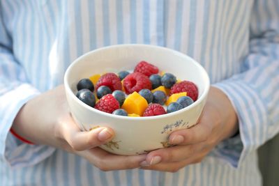 Midsection of woman holding breakfast in bowl