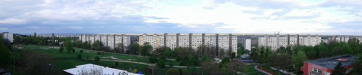 Panoramic view of city against cloudy sky