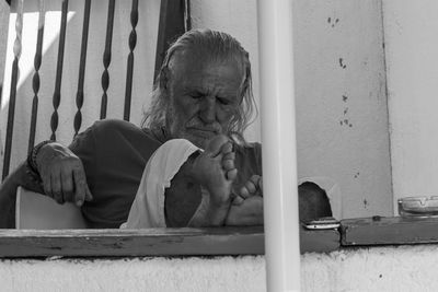 Portrait of man sitting on metal grate