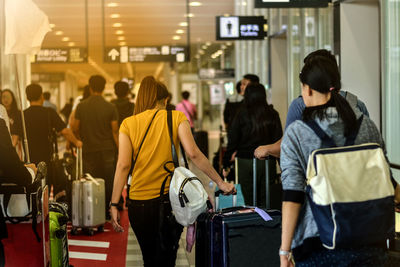 Rear view of people walking in corridor