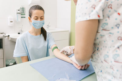 Midsection of doctor vaccinating patient