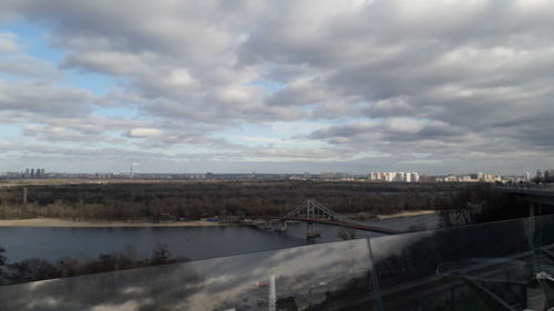 Bridge over river in city against sky