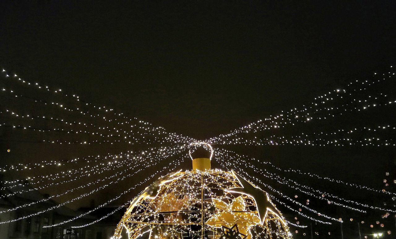 LOW ANGLE VIEW OF ILLUMINATED CHRISTMAS LIGHTS AGAINST SKY