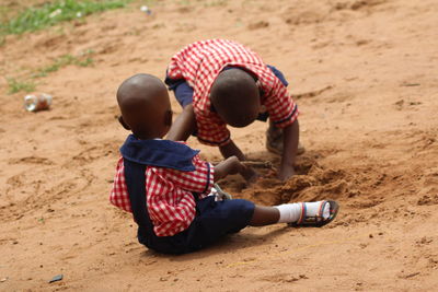 Friends digging soil on field