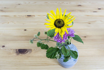 Close-up of yellow flower vase on table