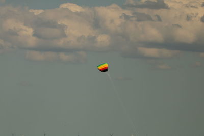 Low angle view of person paragliding against sky