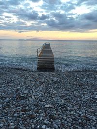 Pier over sea against sky during sunset