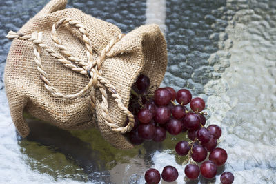 Close-up of grapes in sack on table