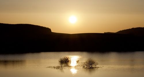 Scenic view of lake against sky during sunset