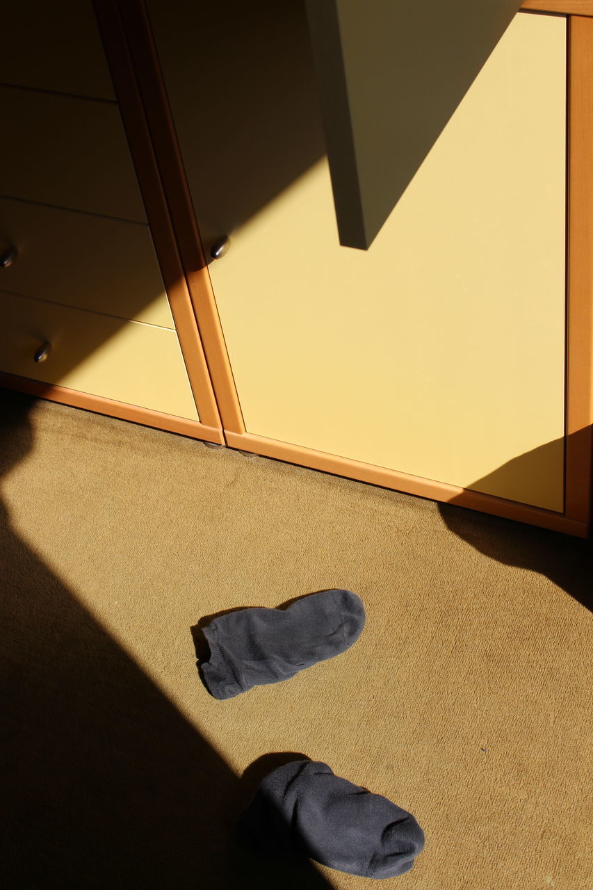 LOW SECTION OF PERSON STANDING ON TILED FLOOR