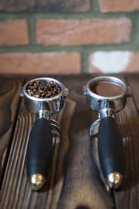 High angle view of coffee in containers on table against brick wall in cafe