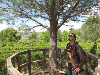 Young man sitting on tree in forest