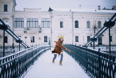 Woman walking on snow covered building