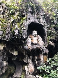Statue of buddha against rock
