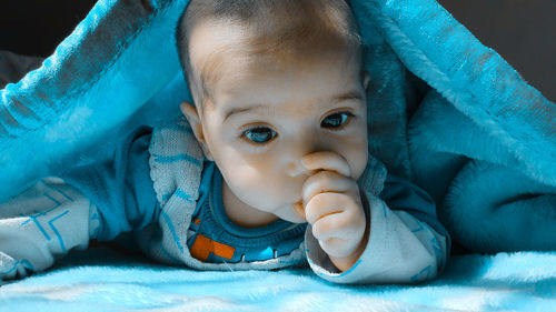 Portrait of cute baby lying down on bed