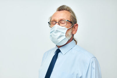 Senior man wearing mask against white background