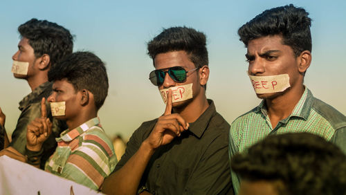 Portrait of friends against sky