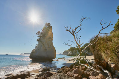 Rocks on beach against clear sky