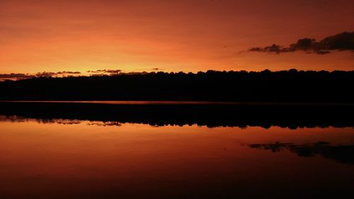 Scenic view of lake against orange sky