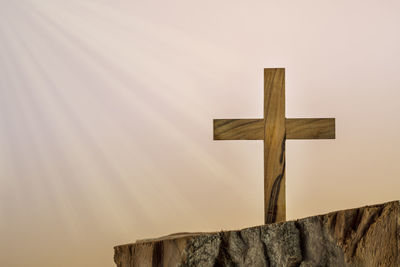 Low angle view of cross against wall