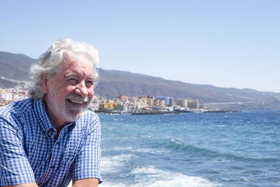 Smiling man in sea against clear sky during day