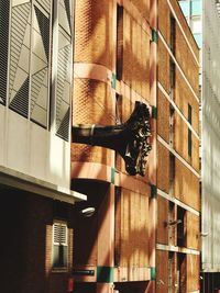 Cat hanging on window of building