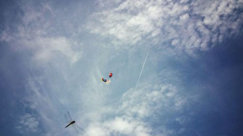 Low angle view of balloons and dragonfly against sky