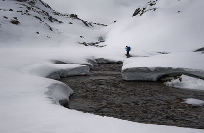 Man on snow covered mountain against sky