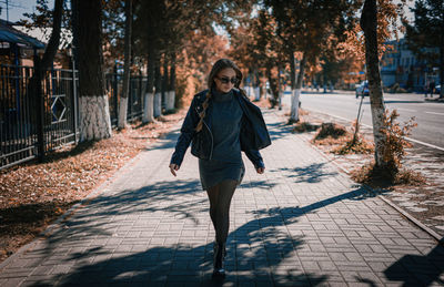 Full length portrait of woman on footpath