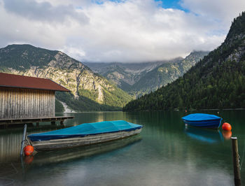 Boats in lake against mountains