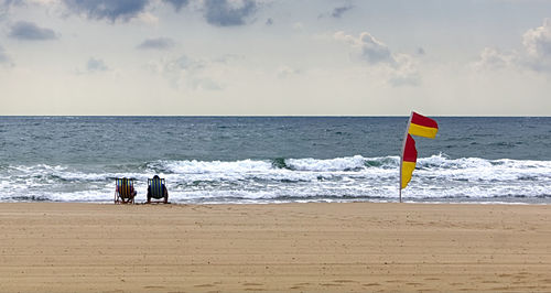 People on beach against sky