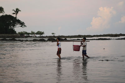 People at beach against sky