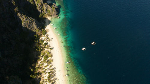 Aerial drone tropical island and sand beach with palm trees. malajon island, philippines, palawan. 