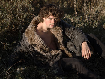 Young man looking away in forest