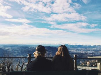 Rear view of couple sitting against beautiful view