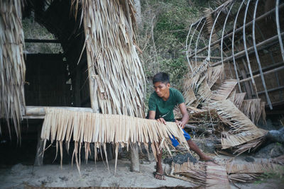 Young man sitting on wood in forest