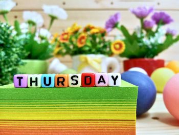 Close-up of colorful blocks with thursday text on stacked papers over table