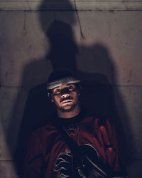 Portrait of young man standing against wall