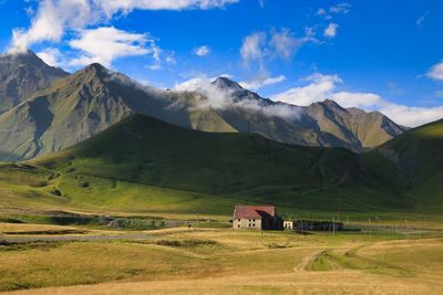 Scenic view of field and mountains against sky