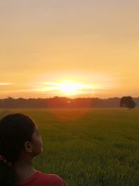 Portrait of boy on field against sky during sunset